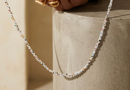 Close-up of the detachable white beaded shoulder strap with delicate multicoloured seed bead accents for an Amal Ayub clutch.