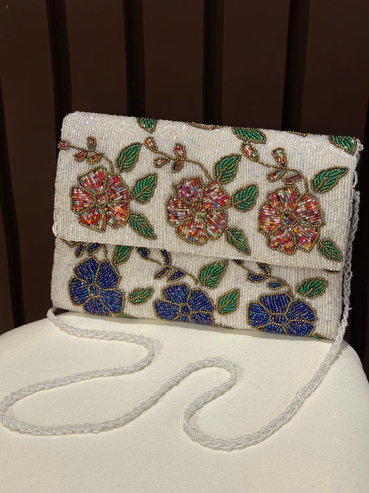 Handcrafted white beaded envelope clutch with colorful botanical pattern by Amal Ayub