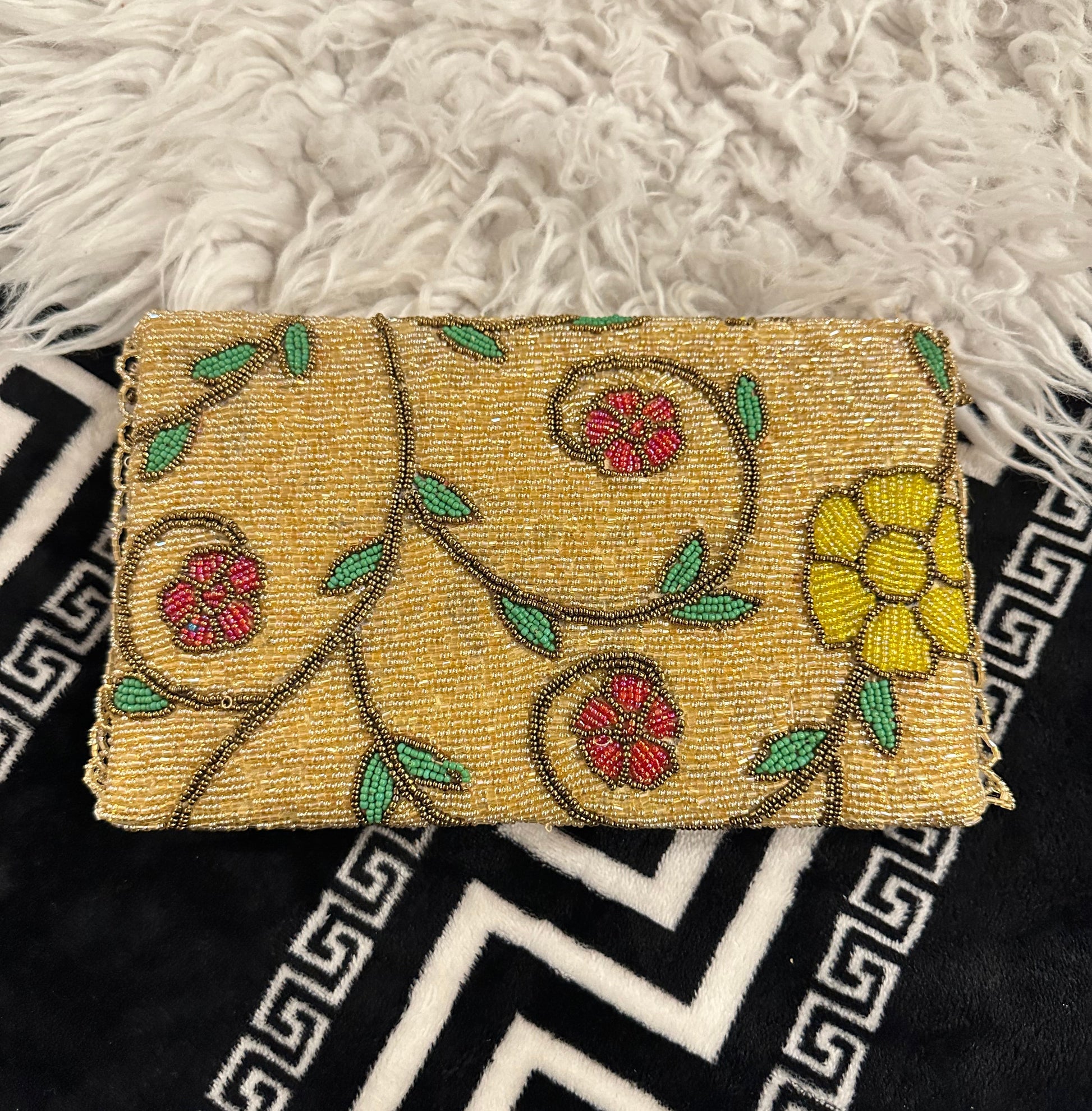 A premium handmade gold and brown structured evening bag featuring a fully embellished beaded base with stunning blue-and-gold and yellow floral designs. Designed by Amal Ayub, this luxury purse is a perfect wedding accessory representing high-end Ladies Hand Bags Pakistan