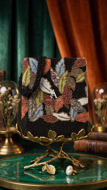 Amal Ayub structured rectangular tote bag featuring handcrafted earthy leaf beadwork on black seed bead background with braided black handles