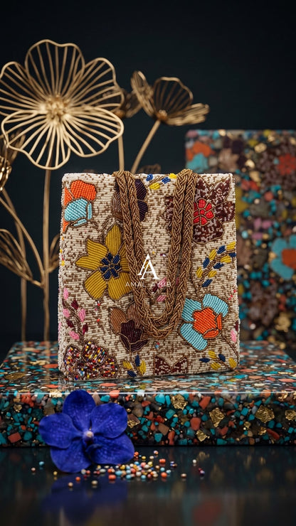 Amal Ayub cream embellished handbag with handcrafted yellow, turquoise, and coral floral beadwork and braided gold handles