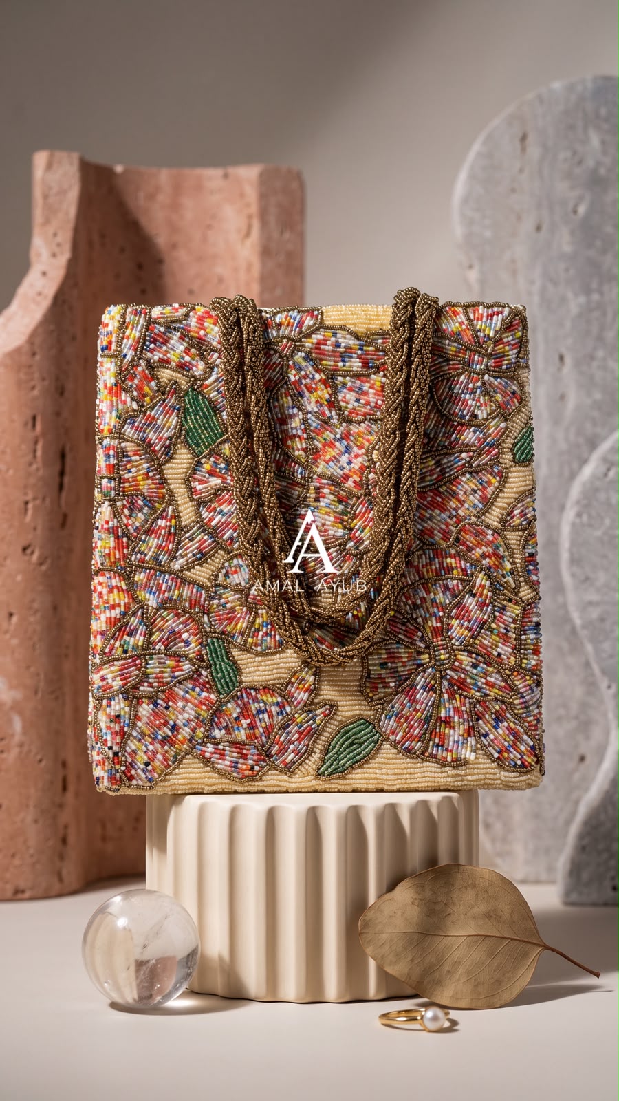 Amal Ayub structured cream tote bag with multi-colored floral beadwork and braided gold handles