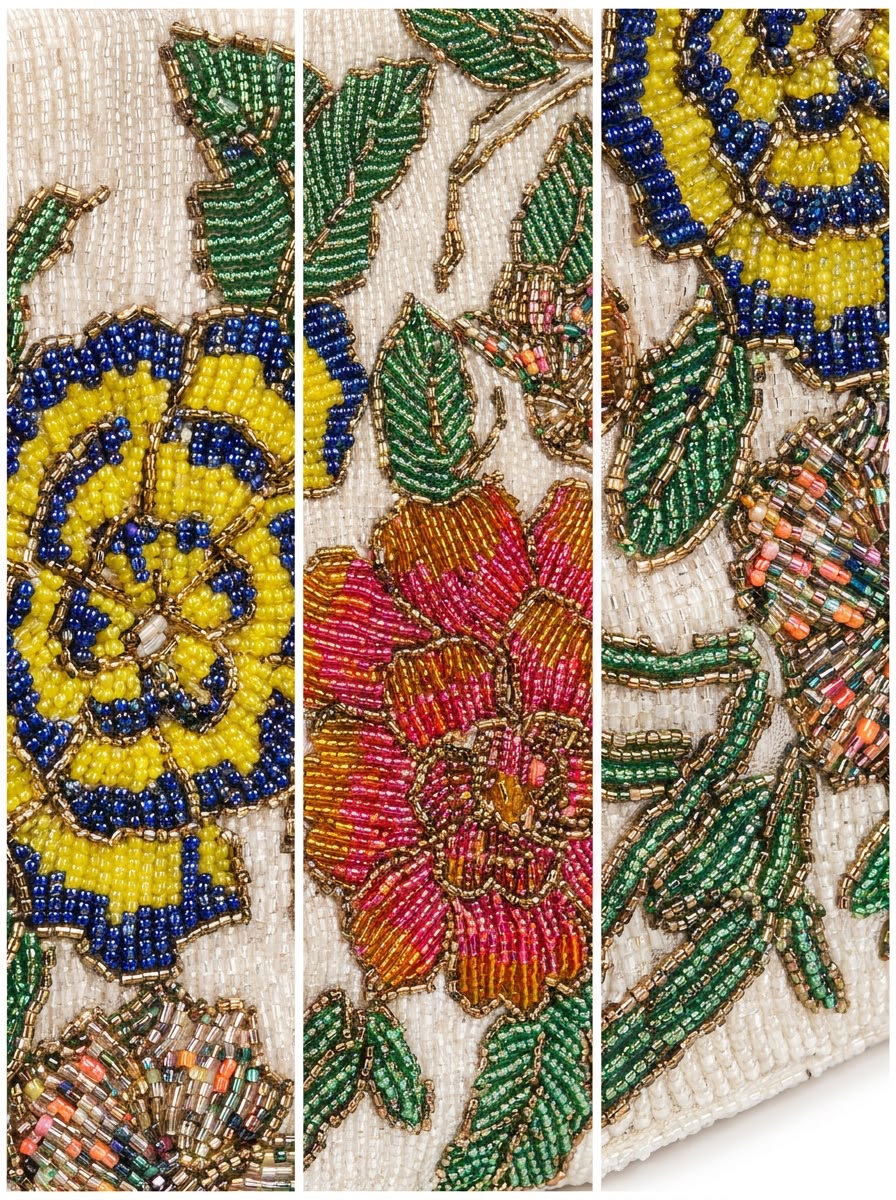 Close-up detail of Amal Ayub hand-embroidered seed bead pink rose and blue-yellow flower with green leaf outlines