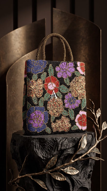 Amal Ayub black hand-embellished tote handbag with blue, purple, and red floral beadwork and braided gold top handles