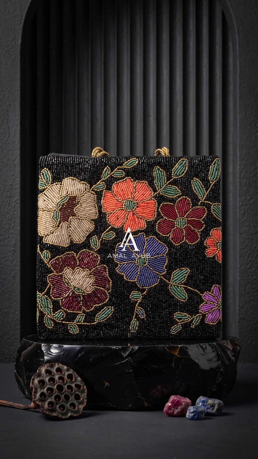 Amal Ayub jet-black handmade bag featuring handcrafted coral, violet, and cream floral beadwork with braided gold handles