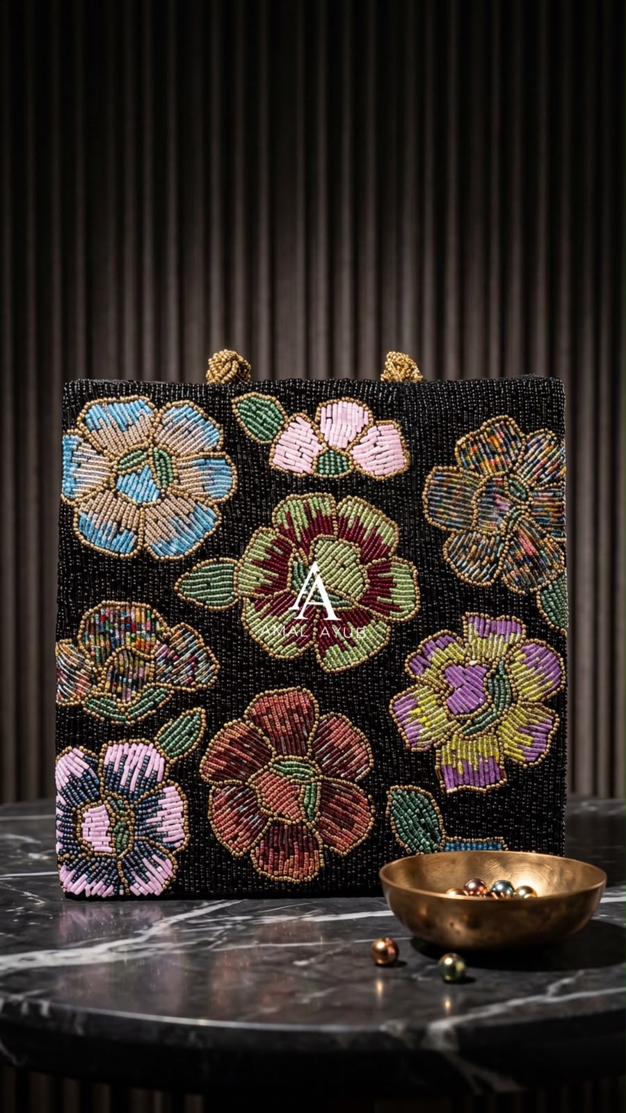 Amal Ayub black handmade bag featuring handcrafted pastel pink, lavender, and blue floral beadwork with braided gold handles