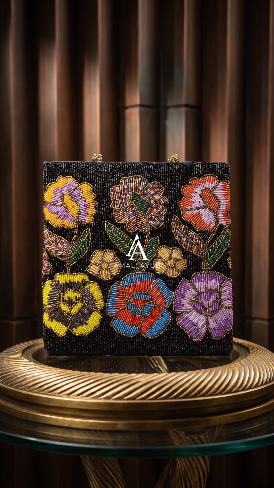 Amal Ayub black hand-beaded box bag with purple, yellow, and coral floral beadwork and gold ball clasp