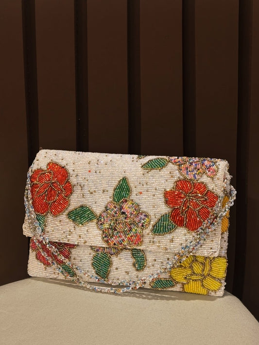 Hand-beaded white floral clutch purse with red and yellow embroidery by Amal Ayub